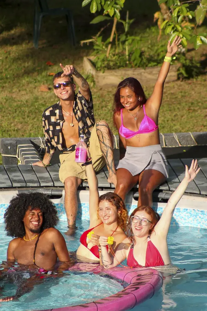 Fiesta en la piscina con los brazos en alto